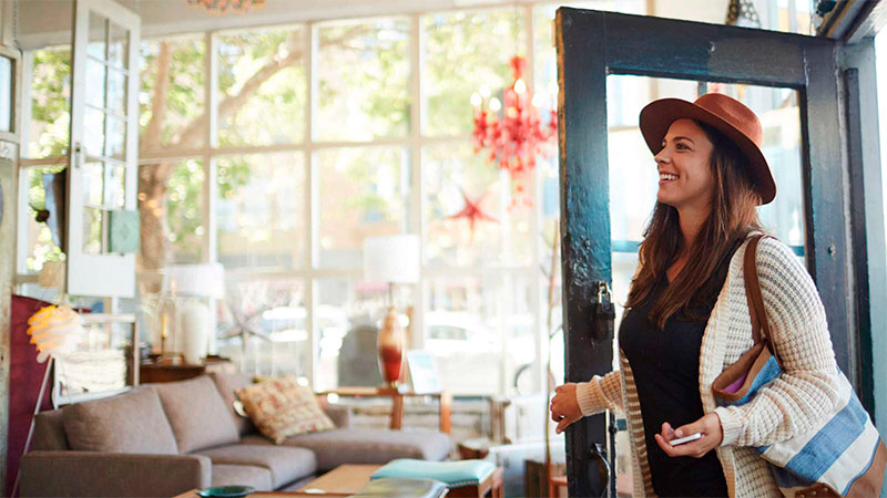 Mujer sonriendo entrando a un local