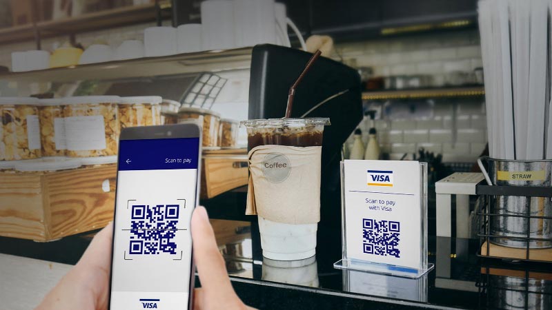 Persona pagando con su celular con código QR