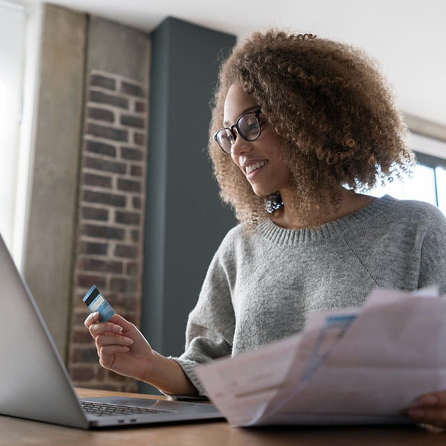 Mujer en notebook pagando cuentas