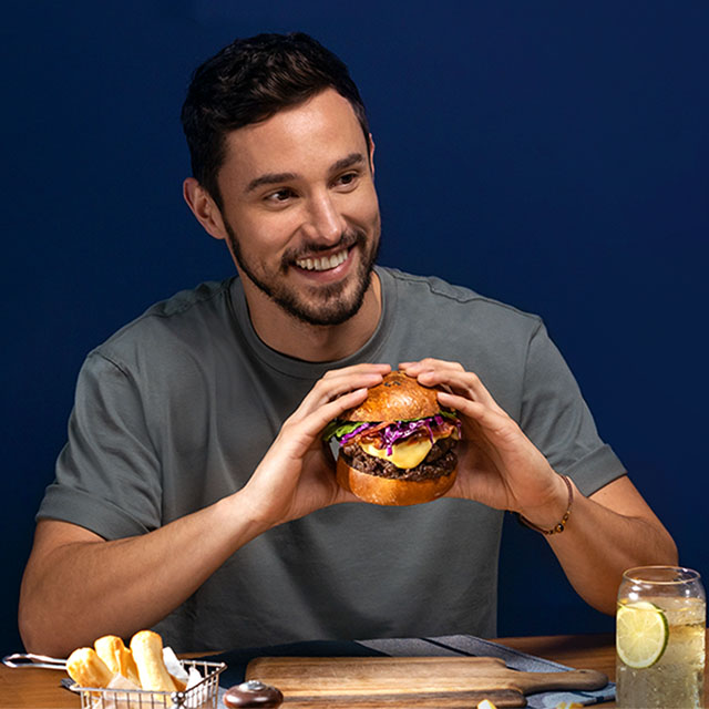 hombre joven comiendo hamburguesa